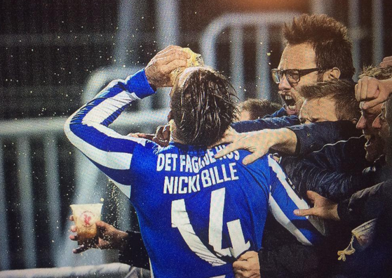 Nicki Bille celebrates injury time equaliser by swigging a fans beer